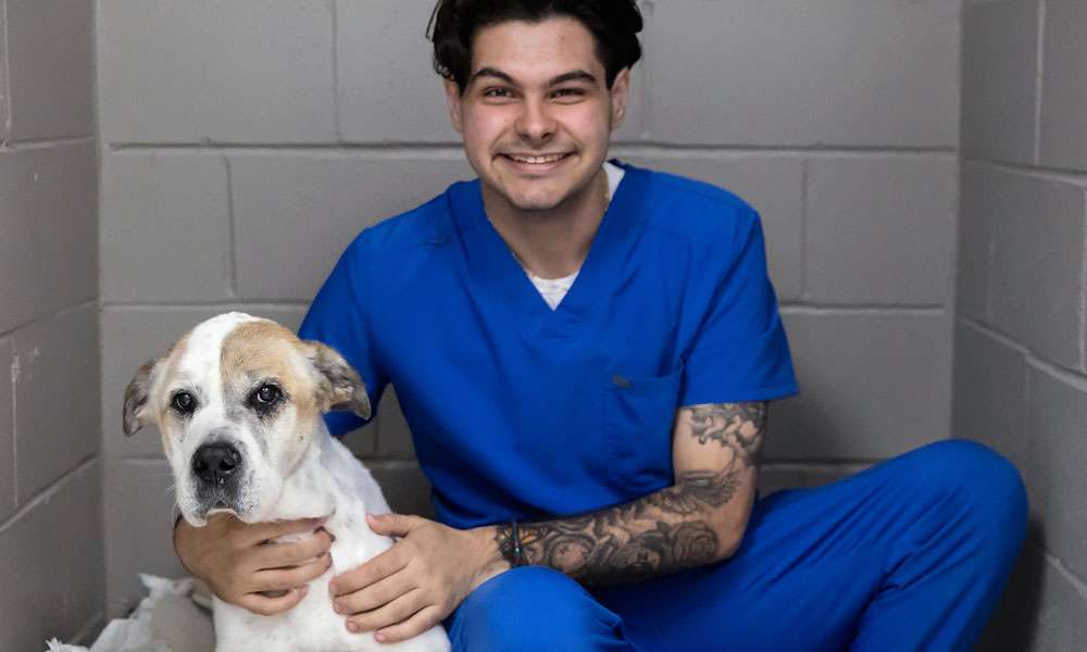 photo of a young man smiling with a dog