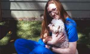 photo of smiling woman holding a dog
