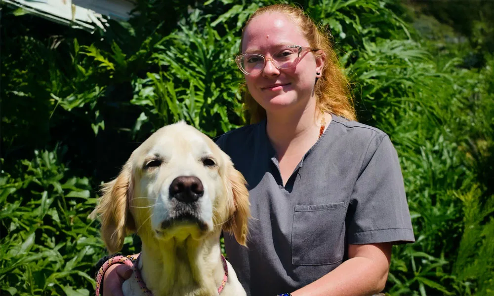 photo of a woman and happy golden retriever