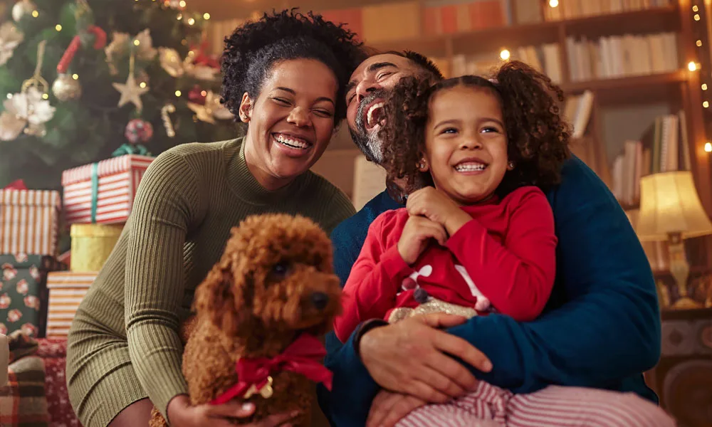 family celebrating winter holidays with their pet at home